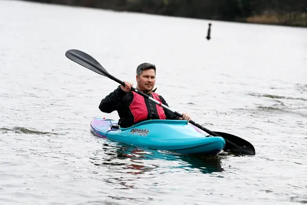 A kayaker paddling on open water