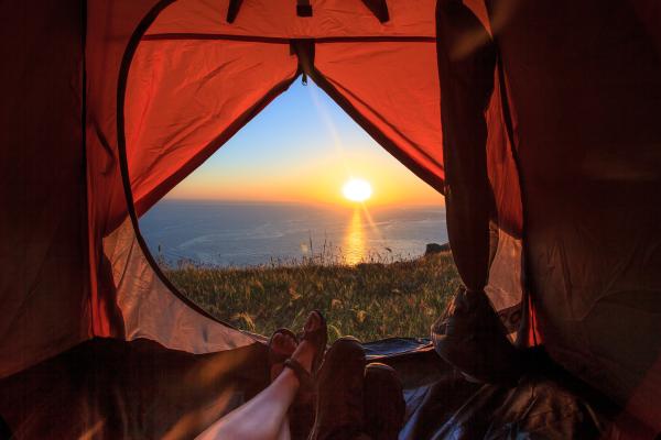 View of a sunset over the sea from inside a tent